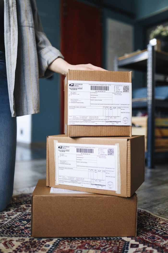 A stack of brown cardboard boxes with shipping labels ready for mail delivery.