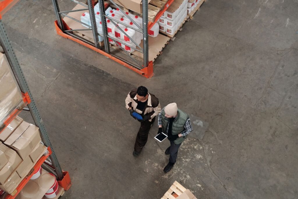 Dos operarios revisando el inventario de un almacén con una tablet.
