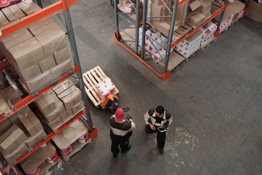 Vista cenital de operarios organizando el inventario de un almacén.