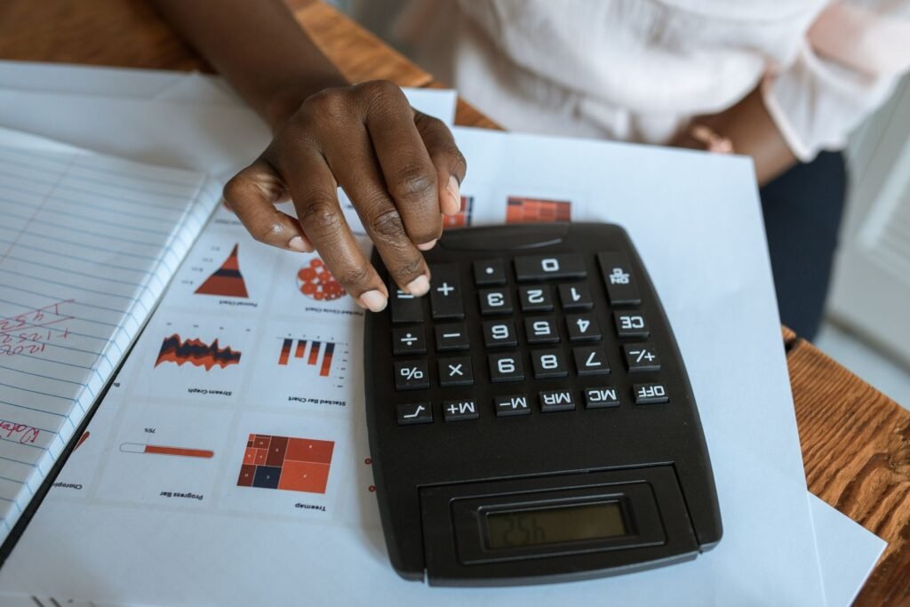 Calculadora sobre una mesa con gráficos e informes financieros.