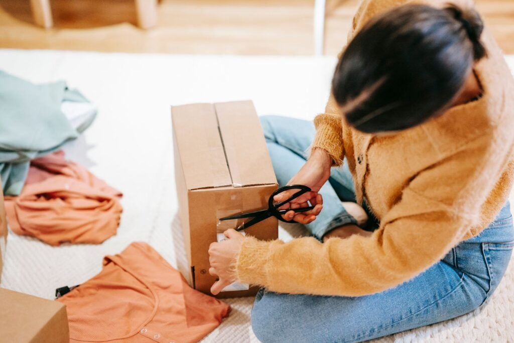 Persona empaquetando un pedido en una caja de cartón.