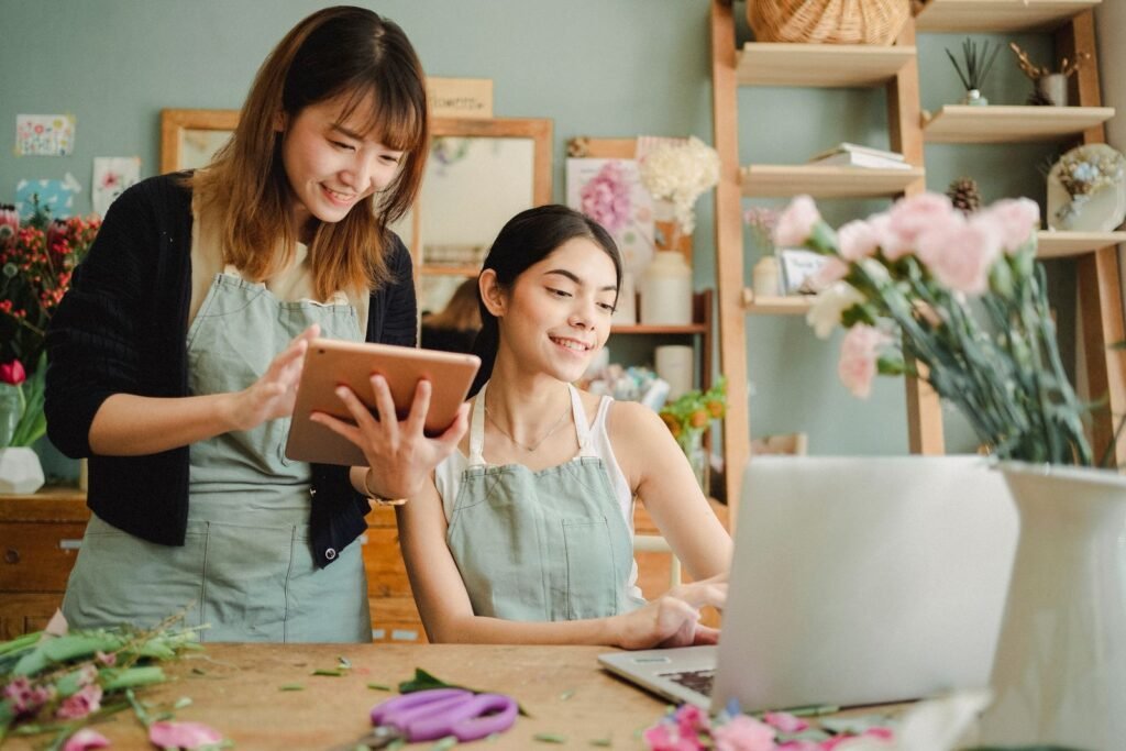 Dos compañeras atendiendo los pedidos online con tablet y portátil.